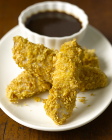 Crunchy chicken fingers with tangy dipping sauce on a plate