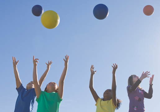 Kids throwing balls over their heads