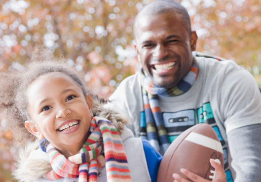 Father and daughter playing football