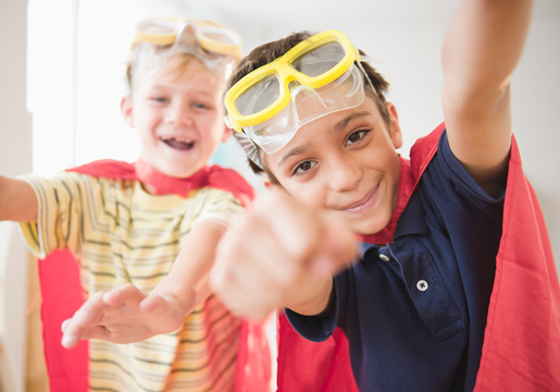 Two boys wearing goggles and capes