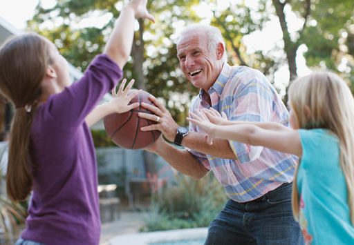 Kids and their grandfather playing basketball