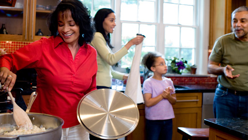 Familia en la cocina mientras la madre prepara la comida