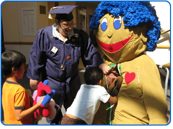 Children and adults play with a large anatomy puppet