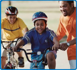 Father teaching children how to ride a bike.