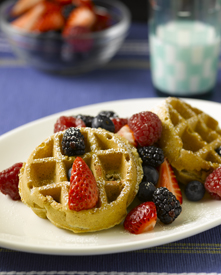 Oatmeal pecan waffles with fruit topping on a plate