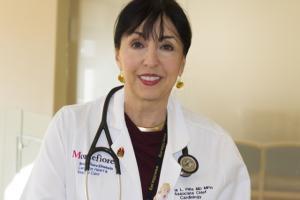 Photo of Dr. Pina wearing a lab coat and stethoscope